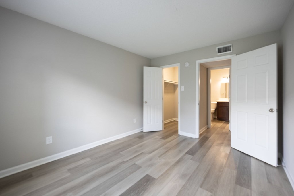 A room with a white door and a grey wall.
