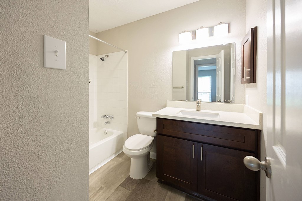 A white sink is in a bathroom with a toilet and a mirror.