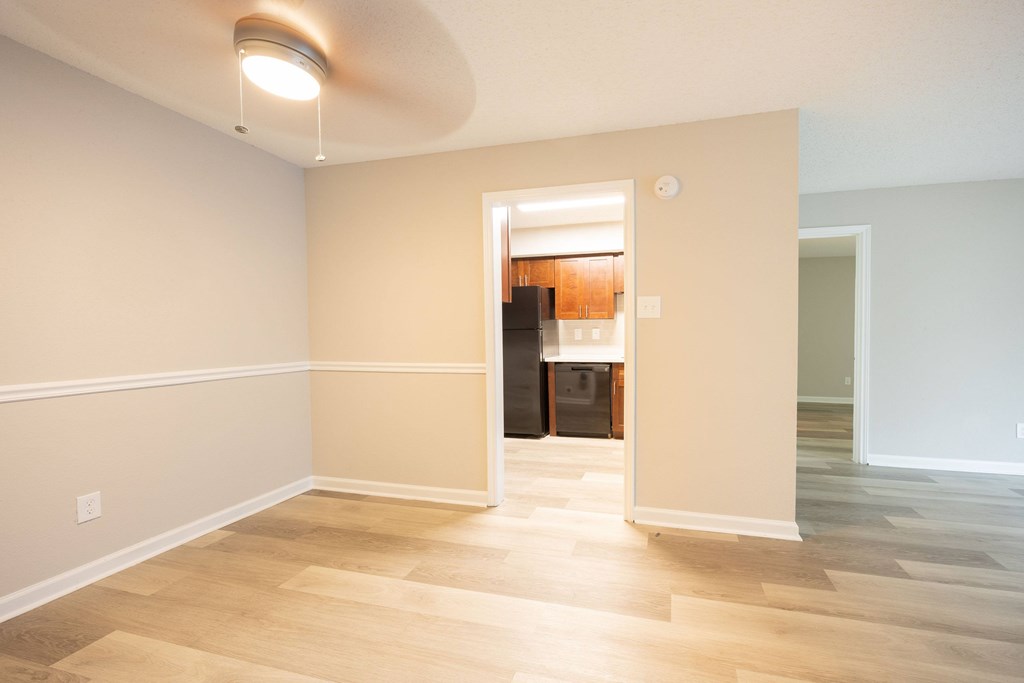 A room with a light on the ceiling and a doorway leading to another room.