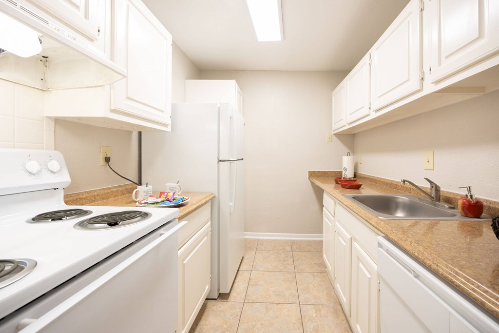 A kitchen with white appliances and cabinets.