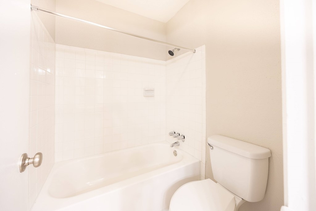 A white toilet is next to a white bathtub in a bathroom.