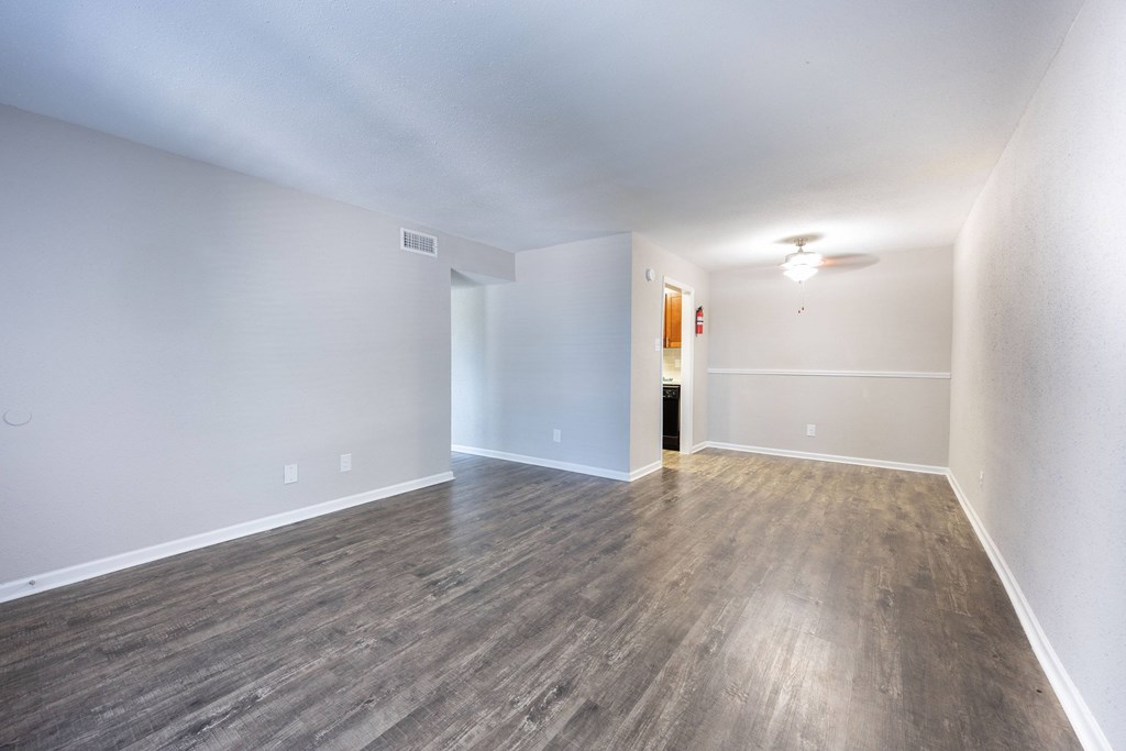 A room with wooden flooring and white walls.