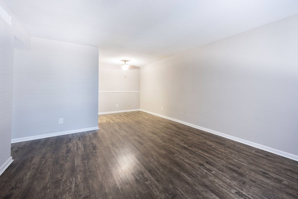 A room with wooden flooring and white walls.