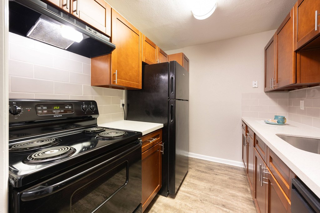 A kitchen with a black stove and black refrigerator.