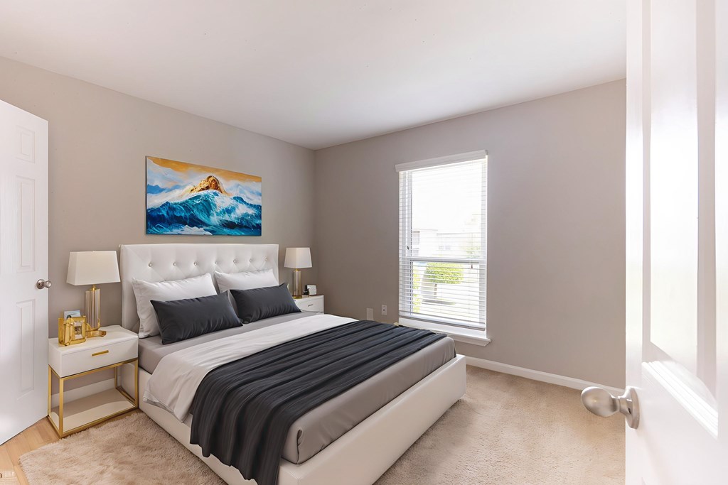 A bedroom with a large bed and a painting of a mountain on the wall.
