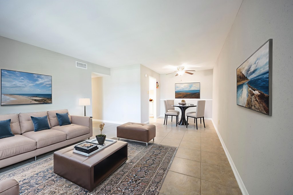 A living room with a couch, coffee table, and a painting on the wall.
