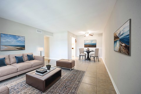 A living room with a couch, coffee table, and a painting on the wall.