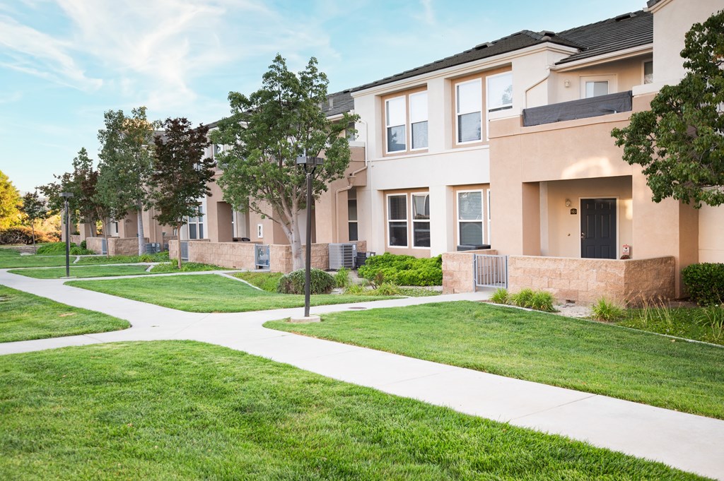 A row of houses with a white pathway in front.