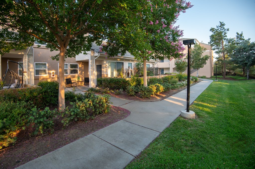 A residential area with apartment buildings and a sidewalk.