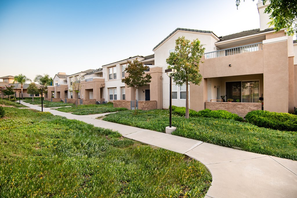 A row of houses with a sidewalk in front.