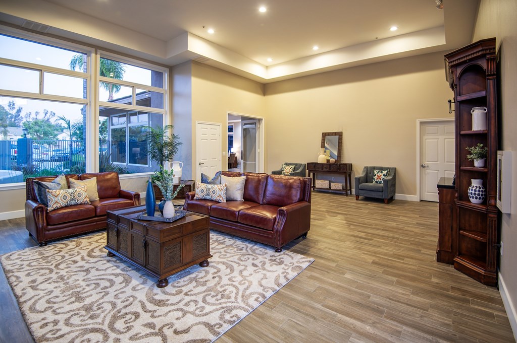 A living room with brown leather couches and a patterned rug.