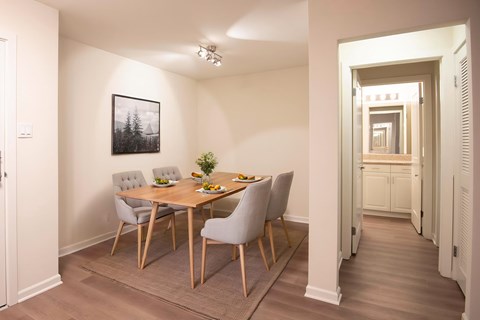 A dining room with a table and chairs.
