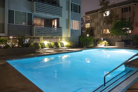 A swimming pool in a residential area at night.