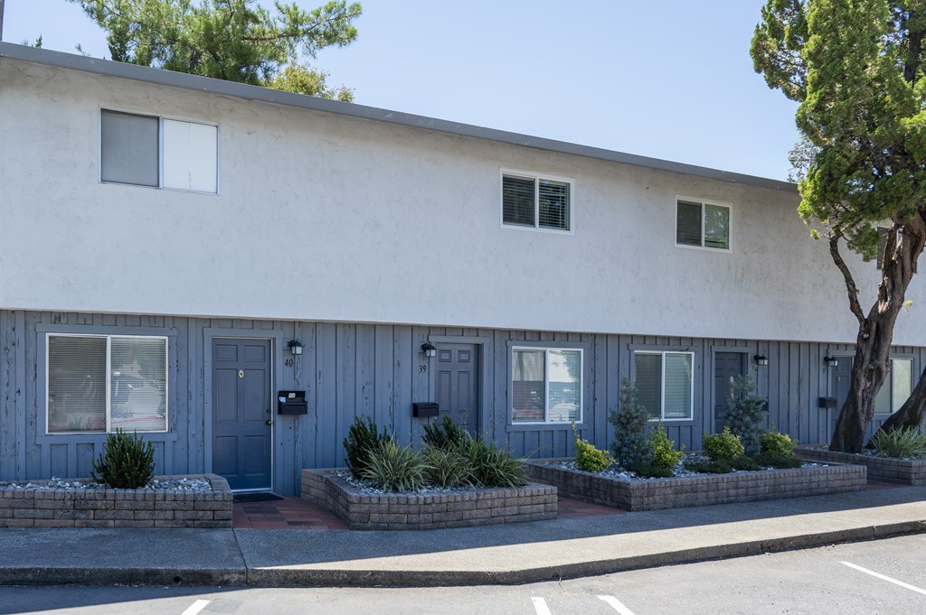A white building with blue doors and windows.