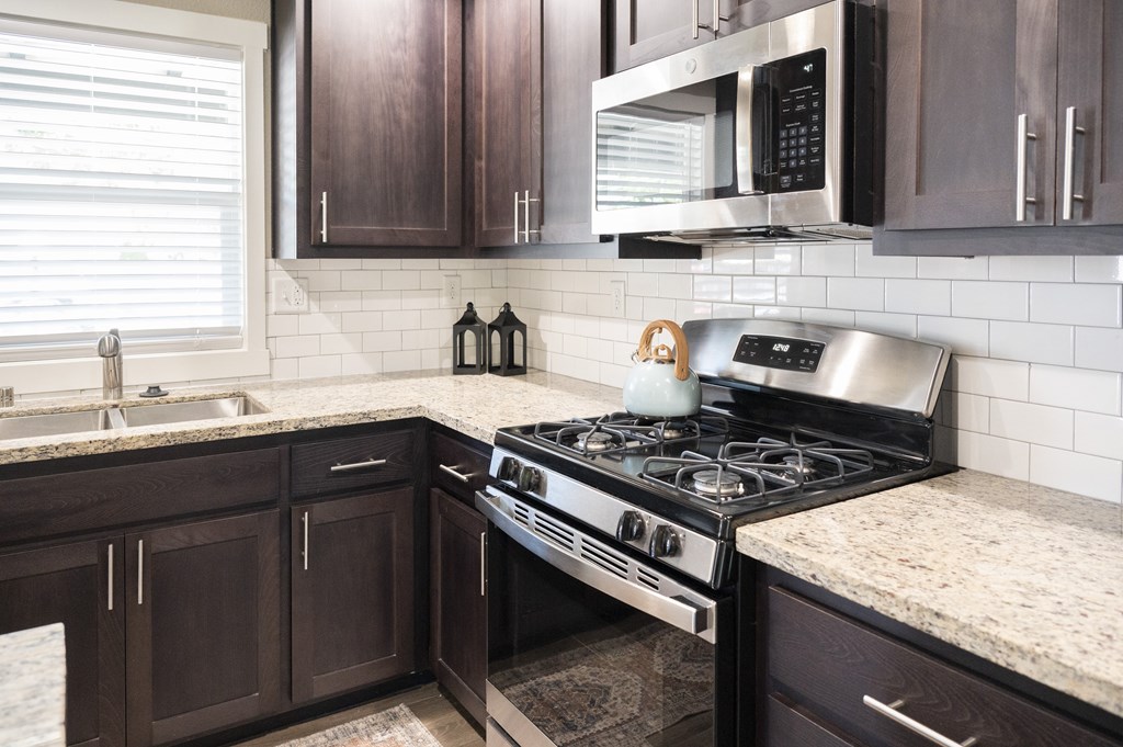 A modern kitchen with a black stove top oven.