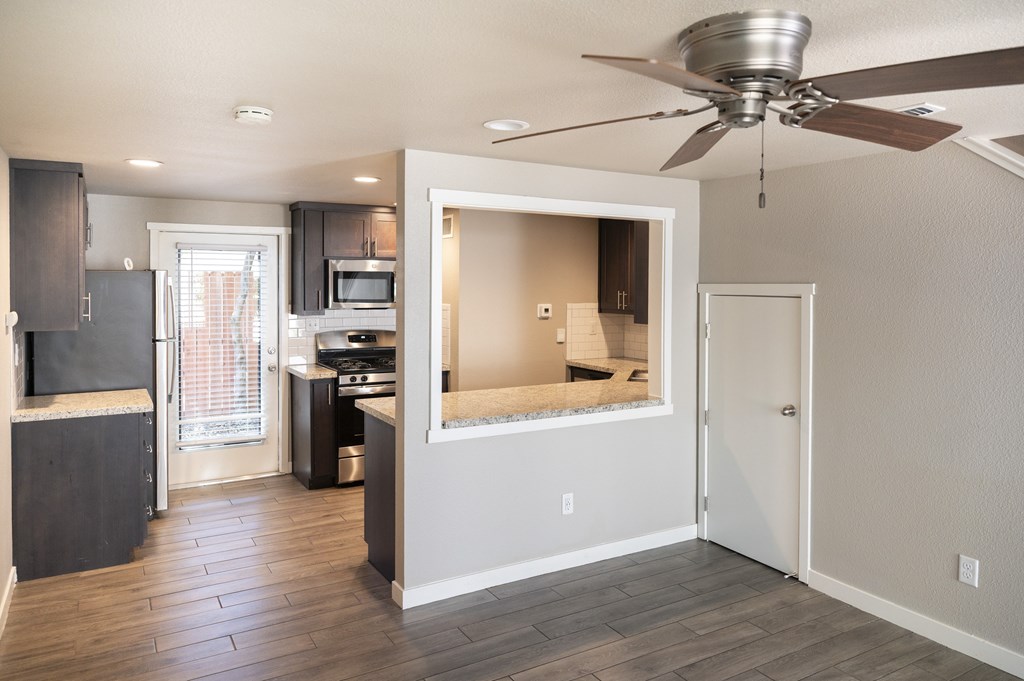 A kitchen with a refrigerator, microwave, and oven.