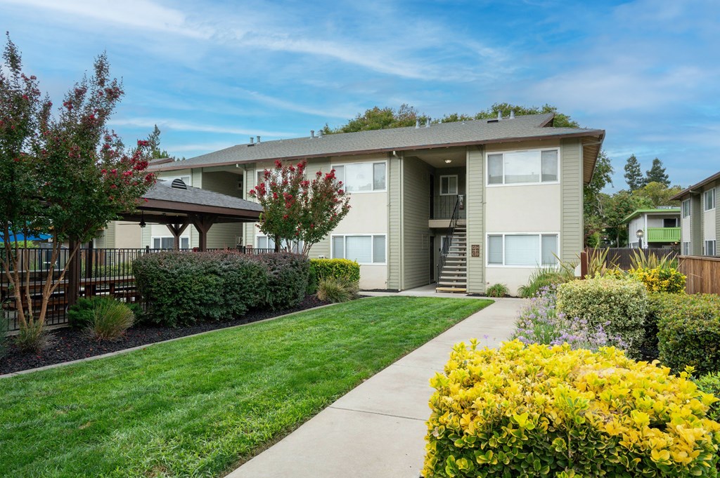 A row of houses with a green lawn in front.