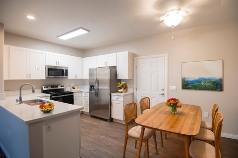 A kitchen with a table and chairs.
