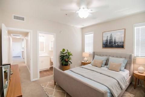 A bedroom with a large bed and a ceiling fan.