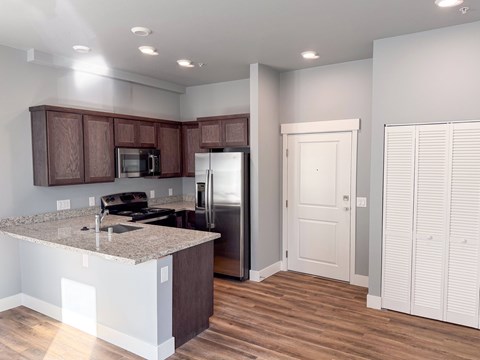 A kitchen with brown cabinets and a granite countertop.