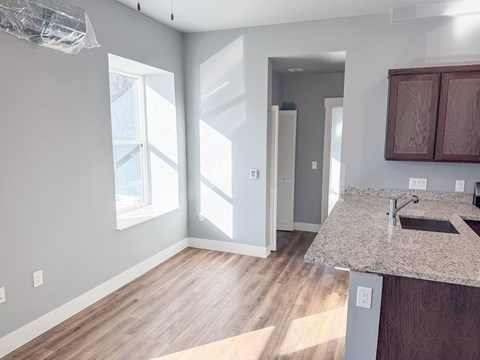 A kitchen with a granite countertop and wooden cabinets.