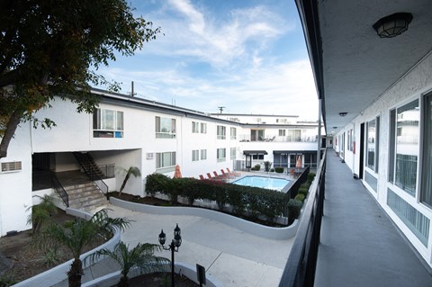 A white building with a pool in the courtyard.