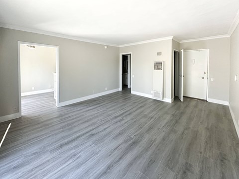 A spacious room with grey flooring and white walls.