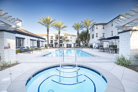 A swimming pool in a resort with palm trees.