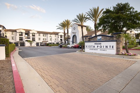 A sign for Vista Pointe Apartment Homes is in front of a building.