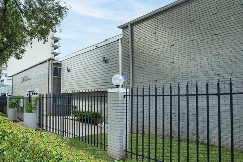 A black metal fence in front of a grey building.