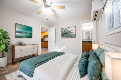 A bedroom with a large bed and a ceiling fan.