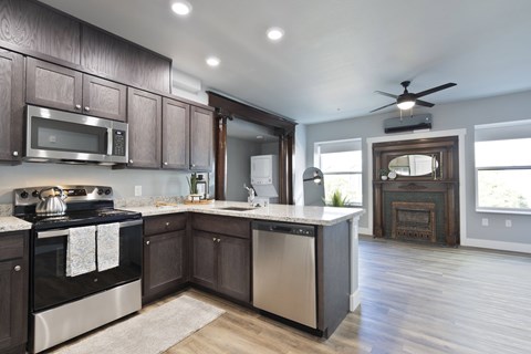 A modern kitchen with dark wood cabinets and stainless steel appliances.