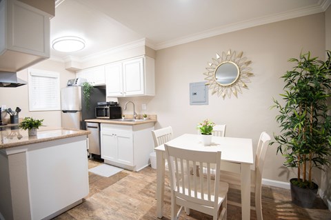 A kitchen with white cabinets and a countertop with a sink.