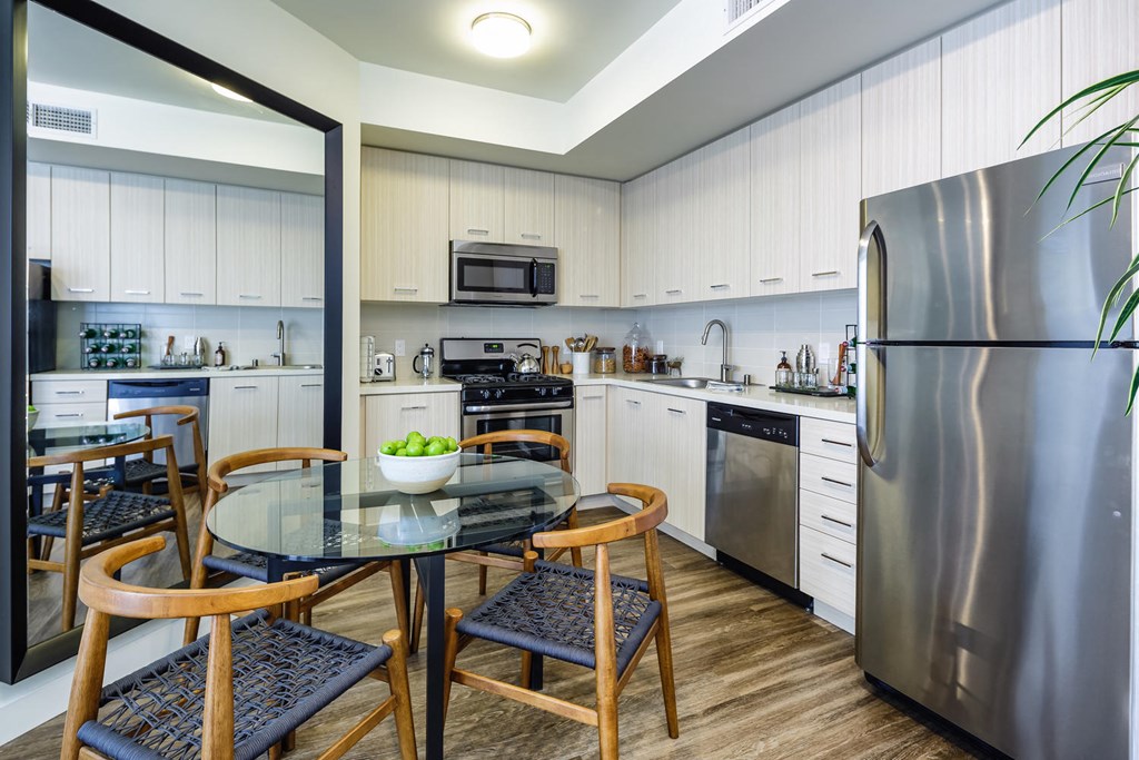 a kitchen with stainless steel appliances and a table with chairs