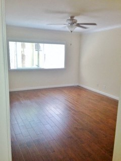 bedroom with wood flooring, ceiling fan, and well lit window