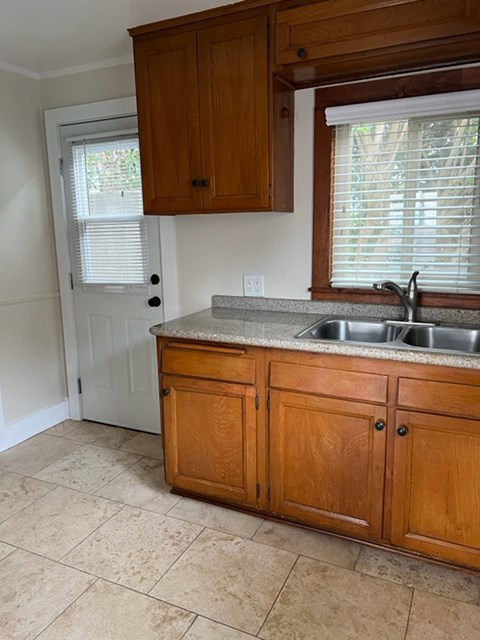 A kitchen with wooden cabinets and a white door.