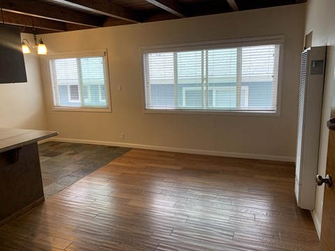 A room with wooden floors and a large window.