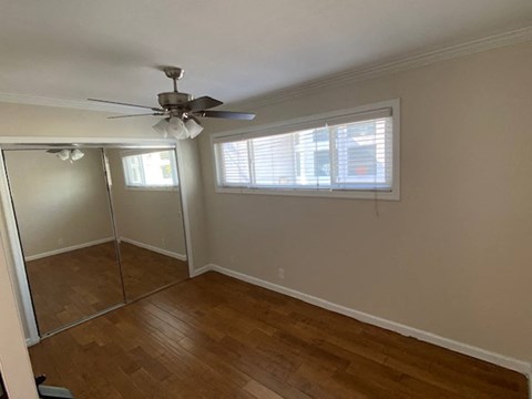 a bedroom with a ceiling fan and a mirror