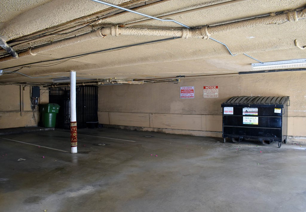 the inside of a parking garage with bins and a pole