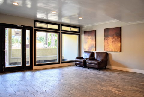 a living room with a leather chair and sliding glass doors