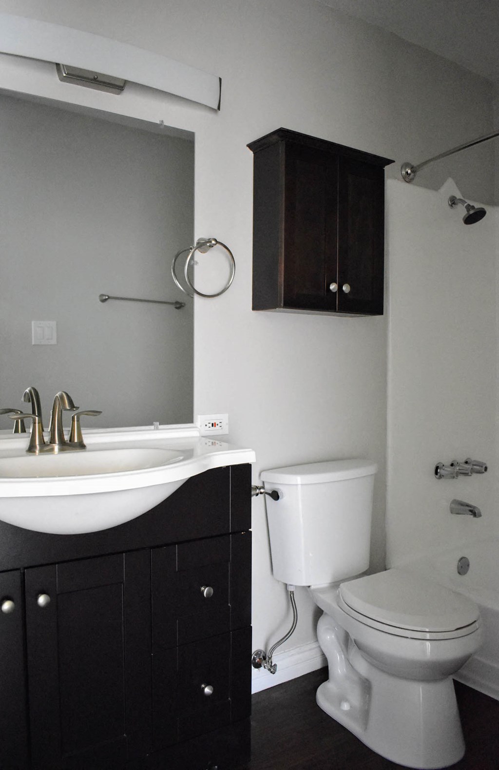 View of bathroom with vanity, inlaid sink, mirror, toilet, storage above, and tub shower combo