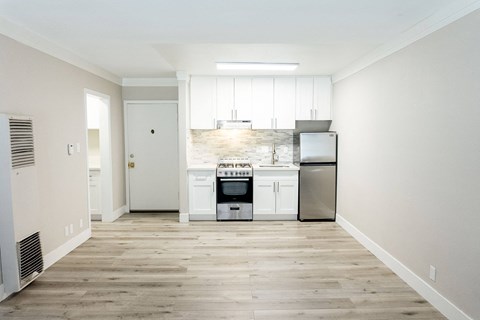 a kitchen with white cabinets and a stove and a refrigerator
