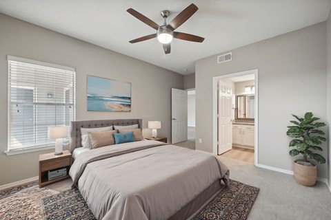 A bedroom with a large bed and a ceiling fan.
