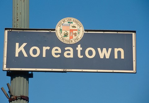 A street sign for Koreatown with a seal on it.