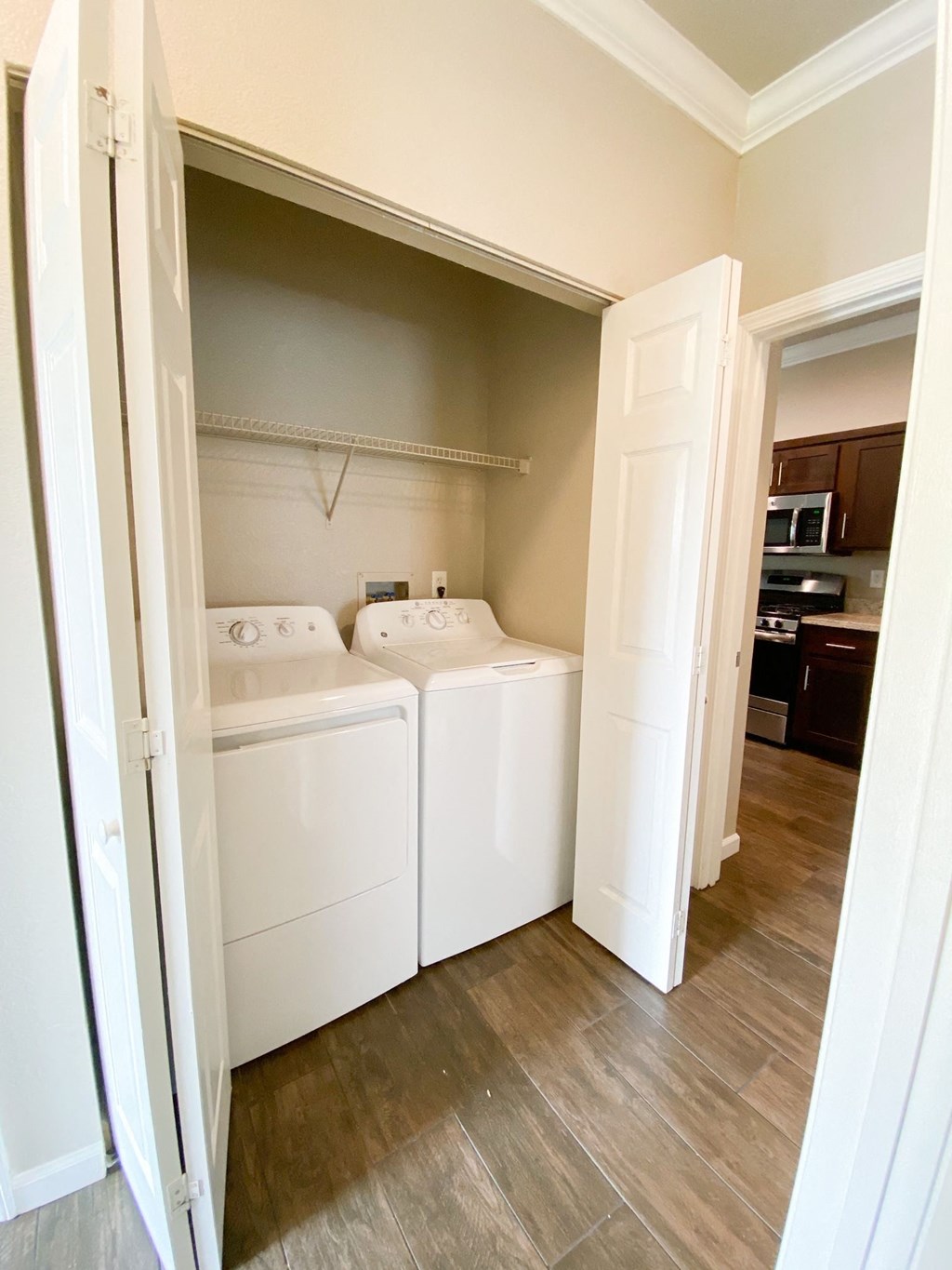 Utility room view with washer and dryer and shelving above