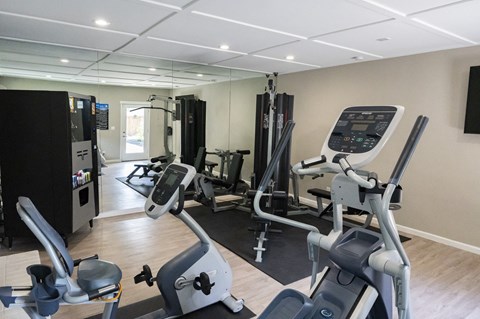 View of community fitness center with stationary bike and weight machines