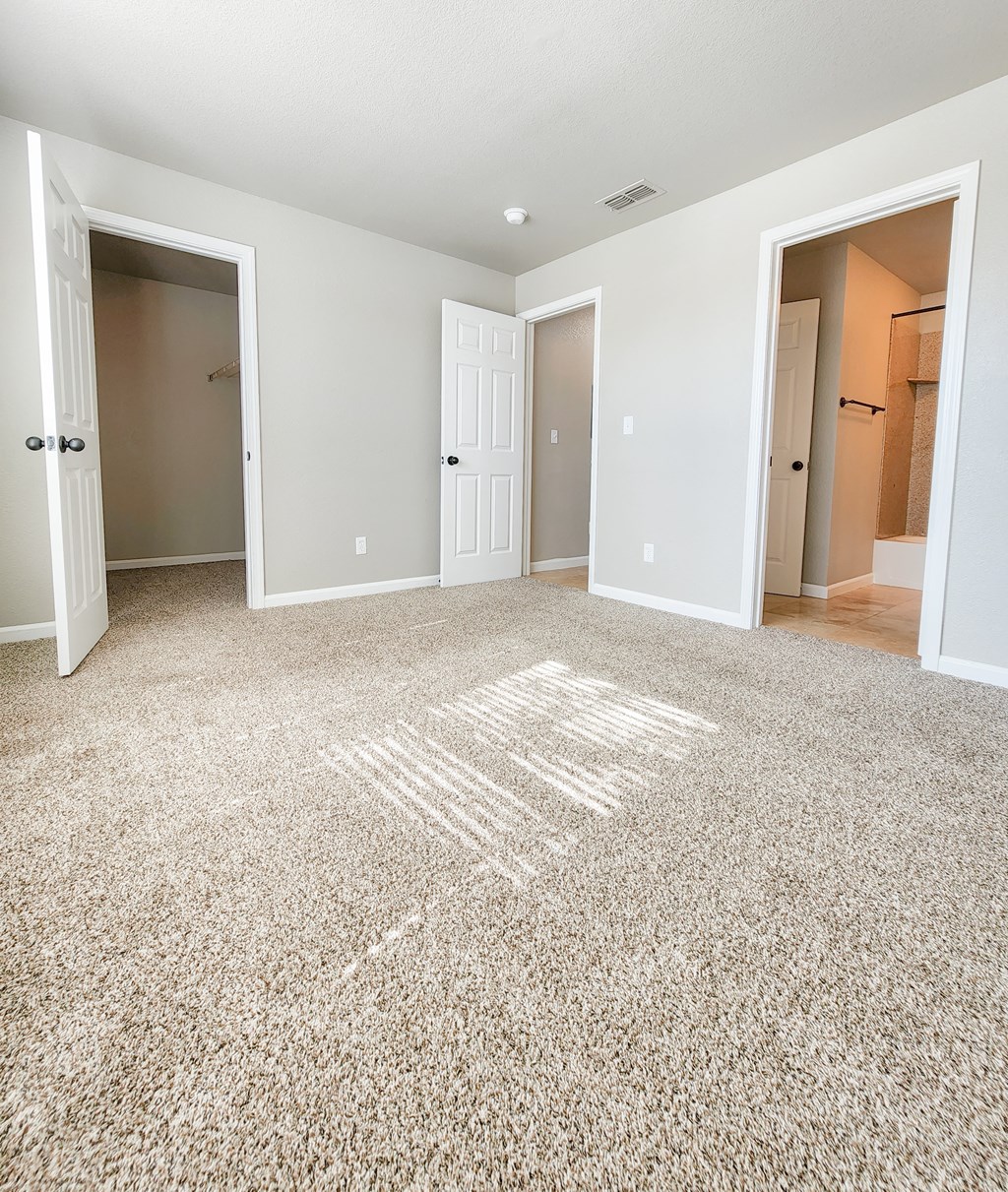 View from bedroom into bathroom, hall way and closet, carpet flooring