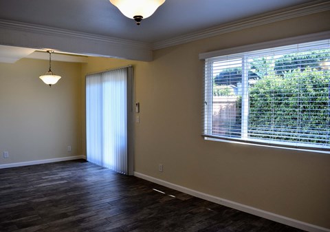 View of living area with well lit window and patio/balcony access through sliding glass door