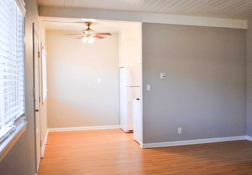 spacious living room area with wooden floors and ceiling fan