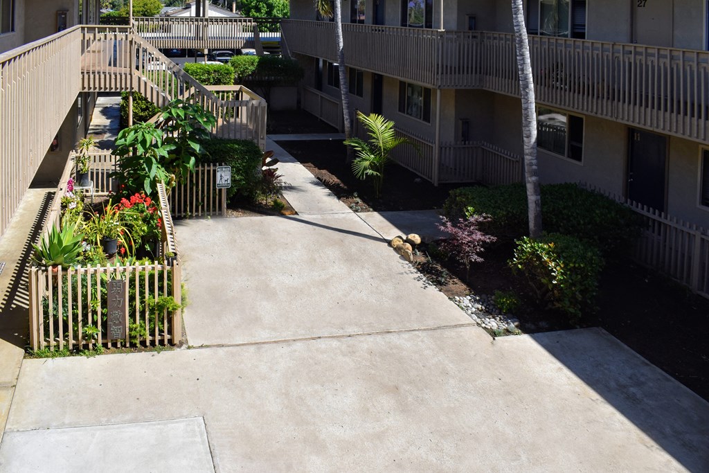 an empty sidewalk in front of an apartment building